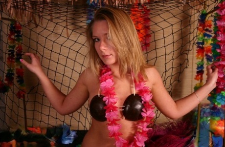 Young solo girl takes off her bikini top after removing a grass skirt