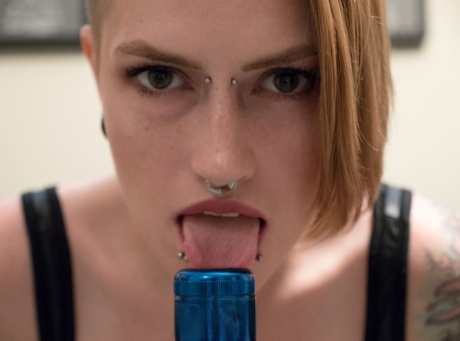 Une fille solo avec des piercings, Amanda Marie, se met une lampe de poche dans le vagin.