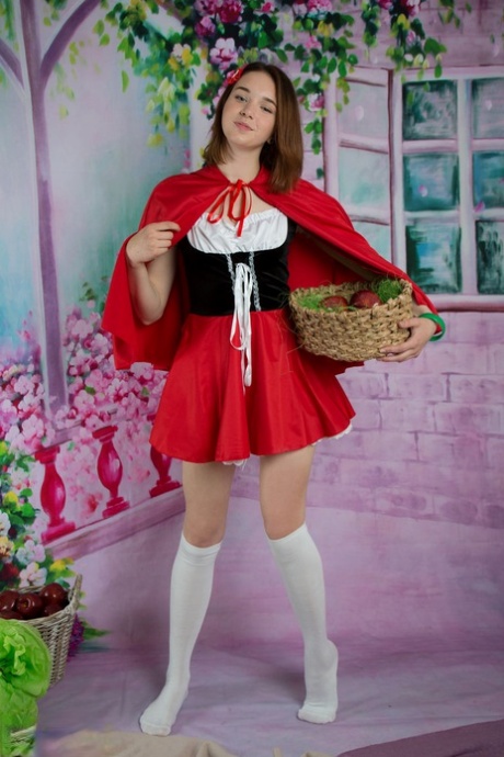 Cosplay dívka Slava vyklouzne z kostýmu a široce roztáhne nohy v ponožkách.