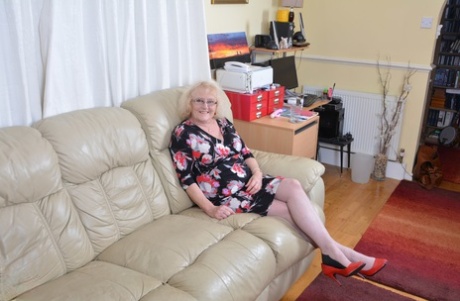 Oude Britse dame in lingerie en gebruinde nylons behaagt zichzelf met een vibrator