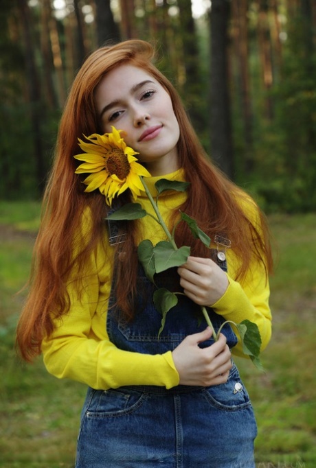 Den rødhårede tenåringsjenta Jia Lissa kler av seg for å posere naken i skogen.