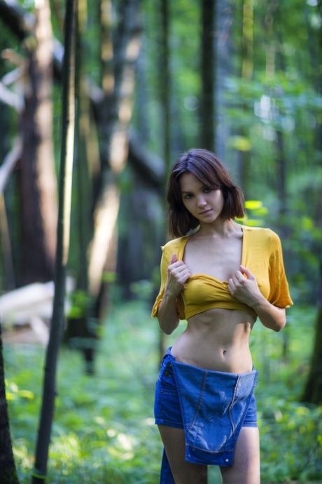 La brune Lara Masier se dénude complètement dans une forêt mature.