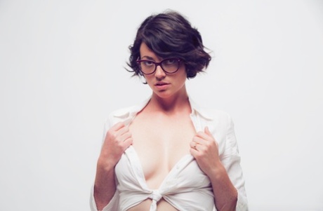 La sexy Terry Haynes mira por encima de sus gafas mientras muestra sus tetas y su coño