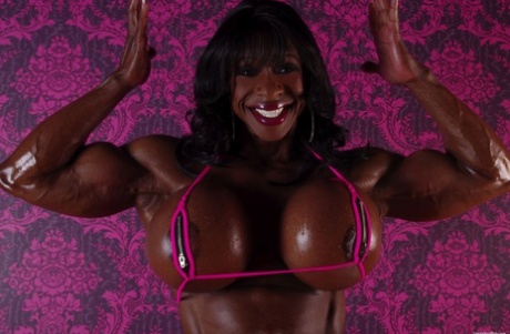 Ebony bodybuilder Yvette Bova laat haar vergrote borsten uit een bikini