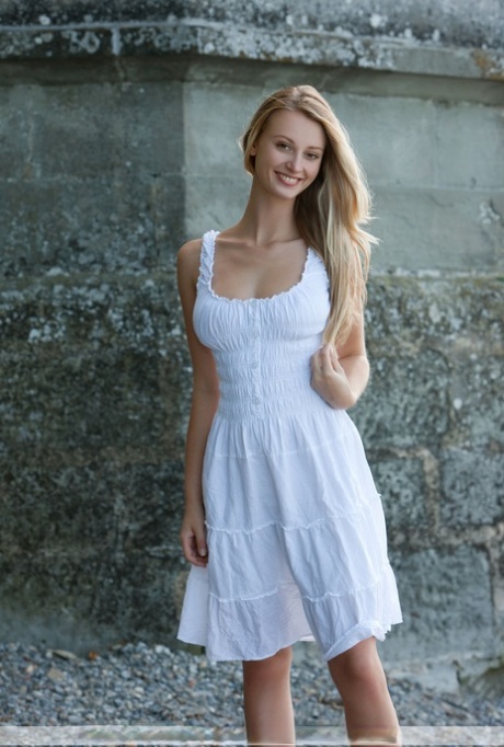 Beautiful blonde Carisha strips her white dress to flaunt big tits outdoors