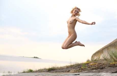 Totally naked blonde Odele strikes great poses while at the shoreline