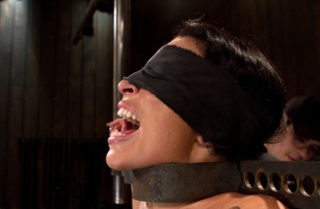 Naked brunette has her screams silenced while being tortured in bondage