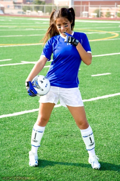 Amy Diaz, une jeune fille en solo, montre les parties de son corps féminin sur un terrain de football.