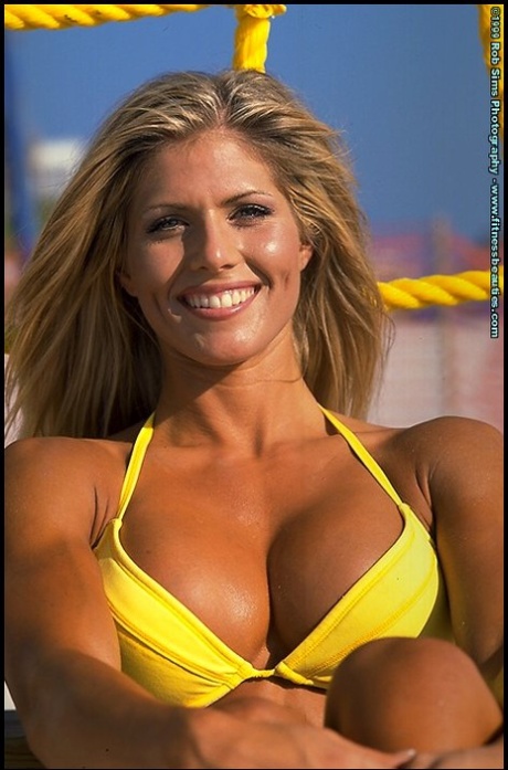 Den blonde fitnessmodellen Torrie Wilson poserer i bikini på stranden.