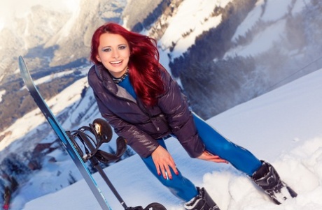 Roodharige chick Lara Larsen gaat snowboarden in een latex catsuit