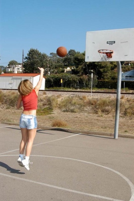 Den søte tenåringen Kellyq viser puppene og rumpa mens hun spiller basket utendørs.