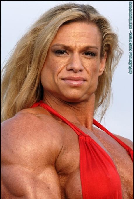 Female bodybuilder Tina Chandler models red swimwear on a beach