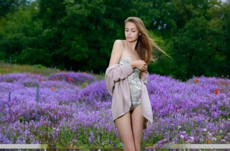 A adolescente Elle Tan, sozinha, mostra a sua figura esbelta diante das flores selvagens.