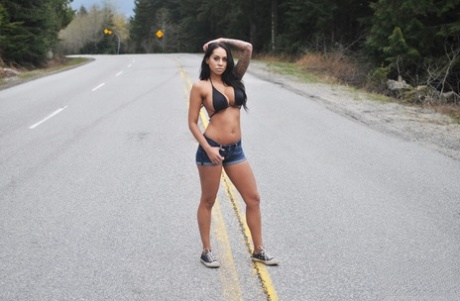 Solo girl Cindy Cupcakes pulls down denim shorts on a roadway
