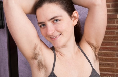 Amateur with big natural tits reveals unshaven pits and bush while disrobing