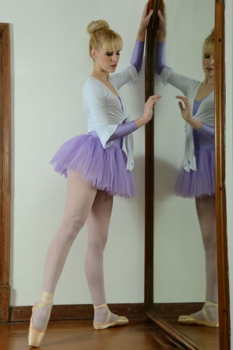 Den blonde ballerinaen Miss Du Bois kler av seg foran et speil.