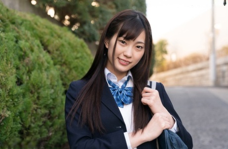 Japanisches Schulmädchen zeigt ihre Unterwäsche unter dem Rock, bevor sie sich bis auf die Socken auszieht