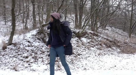 La ragazza solitaria Esperansa piscia su un terreno coperto di neve mentre è infagottata