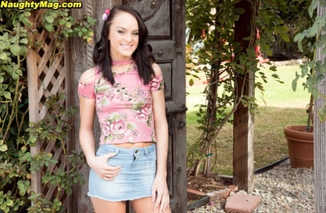 La bella ragazza Kylie Martin espone le sue piccole tette davanti al cancello di un giardino