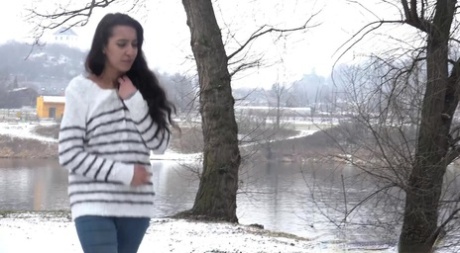 Brunette chick Esperansa pees against a tree upon snow-covered ground