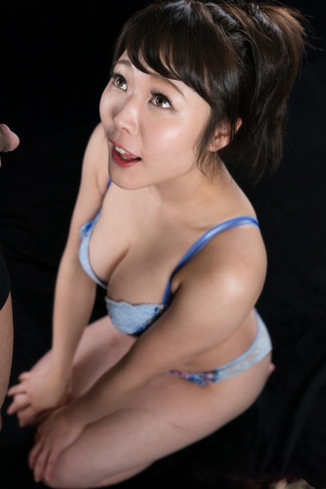Menina japonesa em seu sutiã e conjunto de calcinhas lambe o esperma dos lábios depois de um BJ