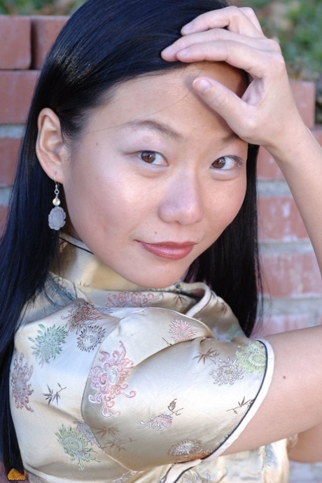 Aziatische eerste timer Niya Yu staat naakt na ontkleden voor een stenen muur