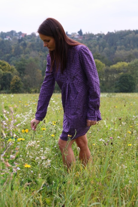 La joven Gloria se desnuda completamente mientras recoge flores en un campo