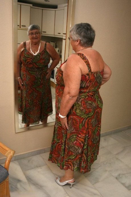 Abuelita de pelo plateado Grandma Libby expone su figura obesa ante un espejo