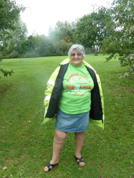 La grassa donna britannica Nonna Libby si espone accanto a un albero in un parco