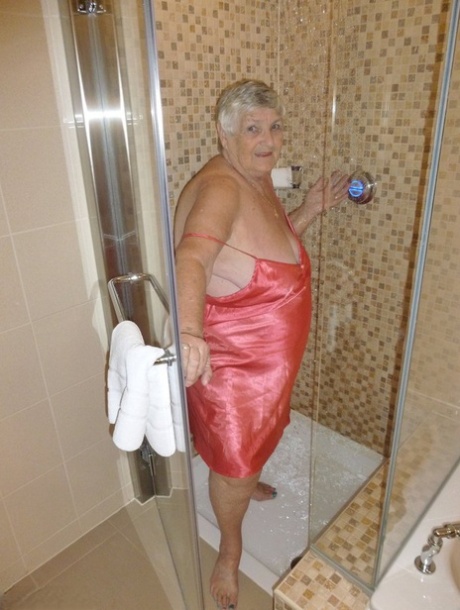 Gammal fet kvinna, mormor Libby, fönar håret efter duschen
