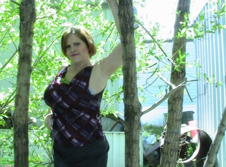 Thick older woman Misha MILF exposes herself in a stand of hardwood trees