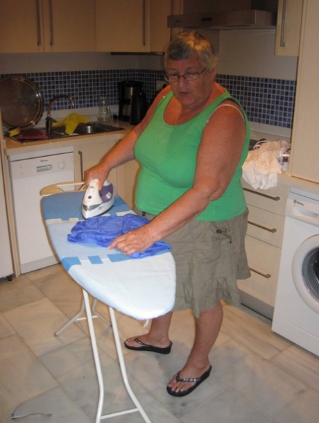 La oma británica con sobrepeso Abuela Libby expone sus tetas mientras plancha