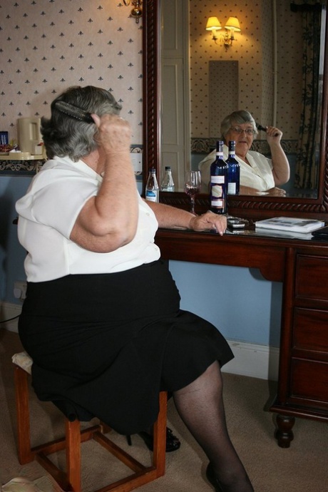 Толстая бабушка с короткими седыми волосами занимается сексом по телефону только в черных чулках