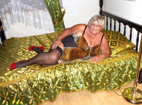 A velha avó amadora Libby leva um grande dildo preto à sua rata numa cama