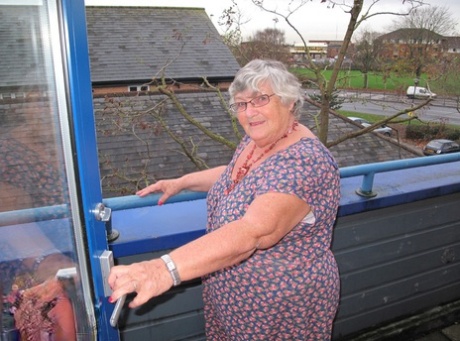 La grassa nonnina britannica Nonna Libby mette a nudo le tette su un balcone prima di spogliarsi