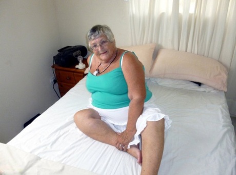 Tlustá babička s krátkými vlasy a obrovským břichem si strčí dildo do kundy