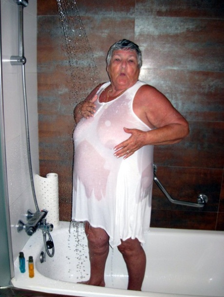 A avó amadora obesa Libby seca o cabelo com o secador depois de tomar um duche