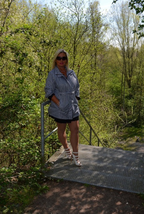 Middle-aged blonde Nude Chrissy exposes herself on a public walking path