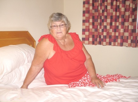 Gorda británica abuela Libby juguetes su coño en una cama en medias de nylon y ligas