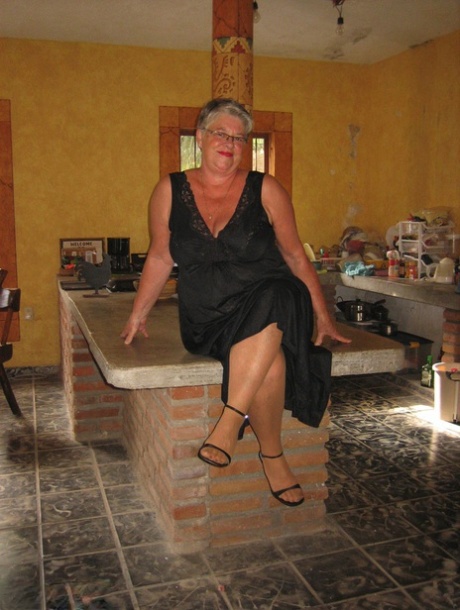 Fat oma Girdle Goddess se déshabille pour bronzer des collants sur un îlot dans la cuisine