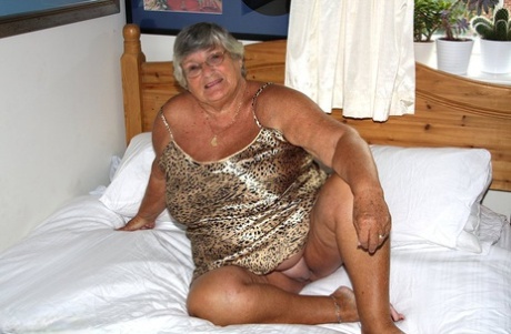 Silver haired senior citizen Grandma Libby masturbates on her bed with a toy