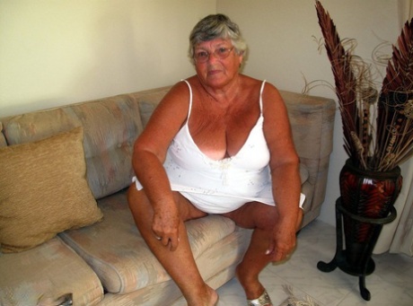 Den feta damen Grandma Libby visar sina hängiga bröst och sin stora röv på en soffa