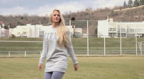 Den blonde pige Katy Sky trækker sine leggings ned, før hun pisser på en fodboldbænk