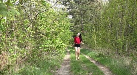 Donkerharig meisje Corin plast tijdens een wandeling op een landweggetje