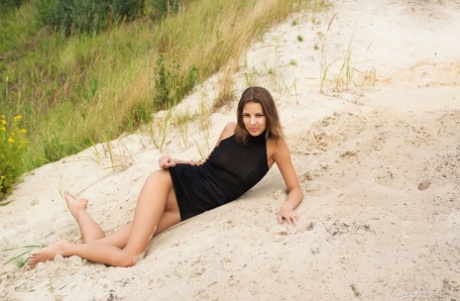 Slender teen Sandra Lauver shows off her tan lined body on a beach dune