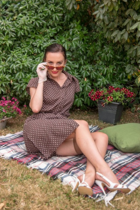 Äldre modellen Sophia Smith poserar utomhus topless i vintagetrosor & strumpeband
