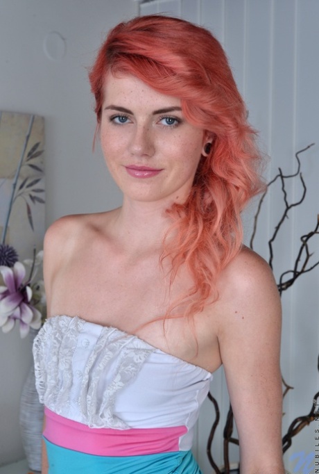 Anna Swix, une adolescente rousse, enlève une robe avant de masturber sa chatte rose.