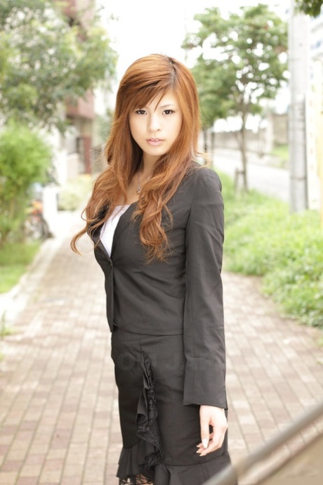 La splendida ragazza asiatica Rina Kikukawa posa in modo seducente completamente vestita outoors