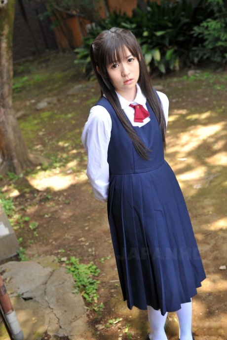 Charmante Japanse babe poseert in haar schattige schooloutfit in de tuin
