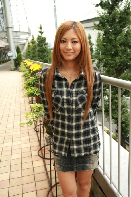La pelirroja japonesa Anna Morisaki chupa una copa vestida con una minifalda